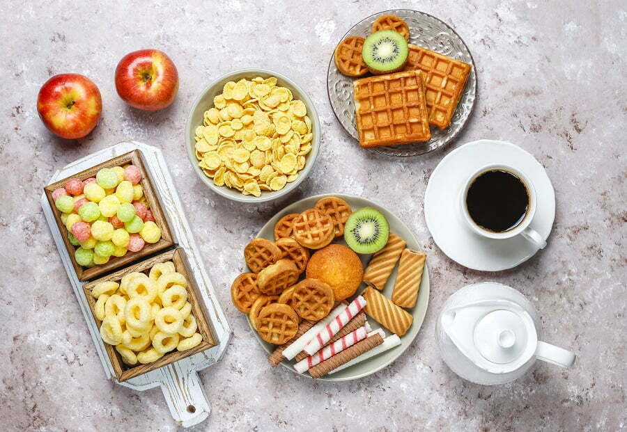 Breakfast with various sweets,wafers,corn flakes and a cup of coffee,top view